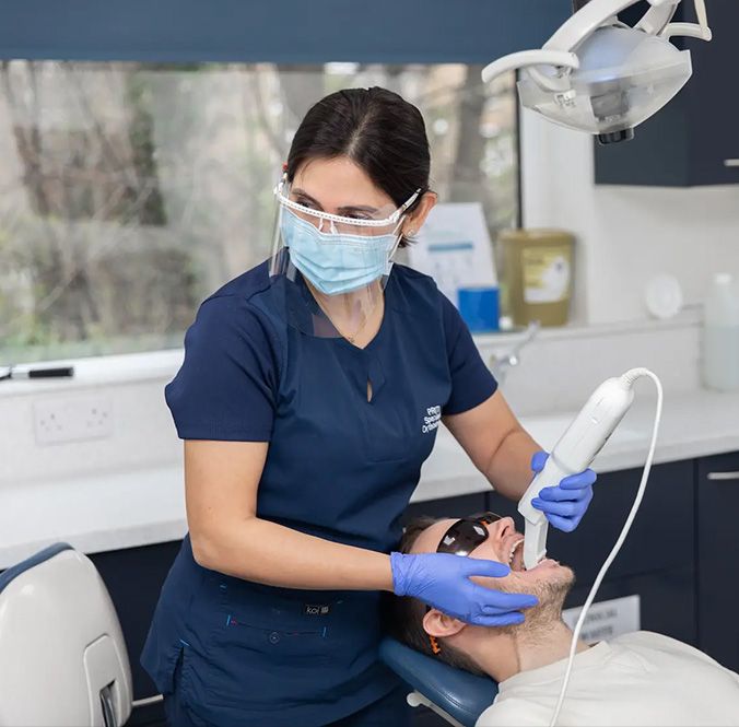 A clinician taking a 3D scan with an intraoral scanner