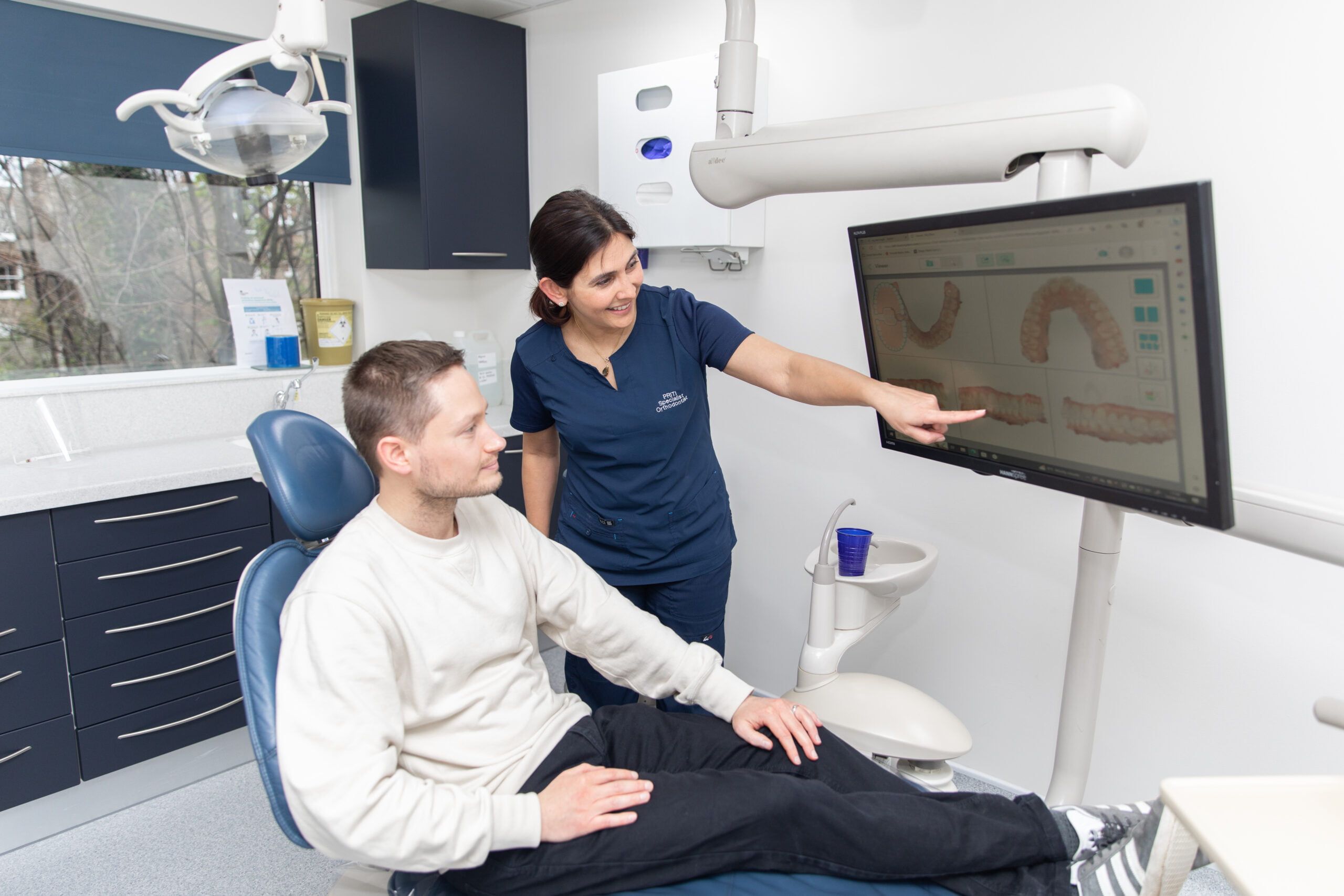 A dentist at Ethicare showing a patient their 3D scan on screen